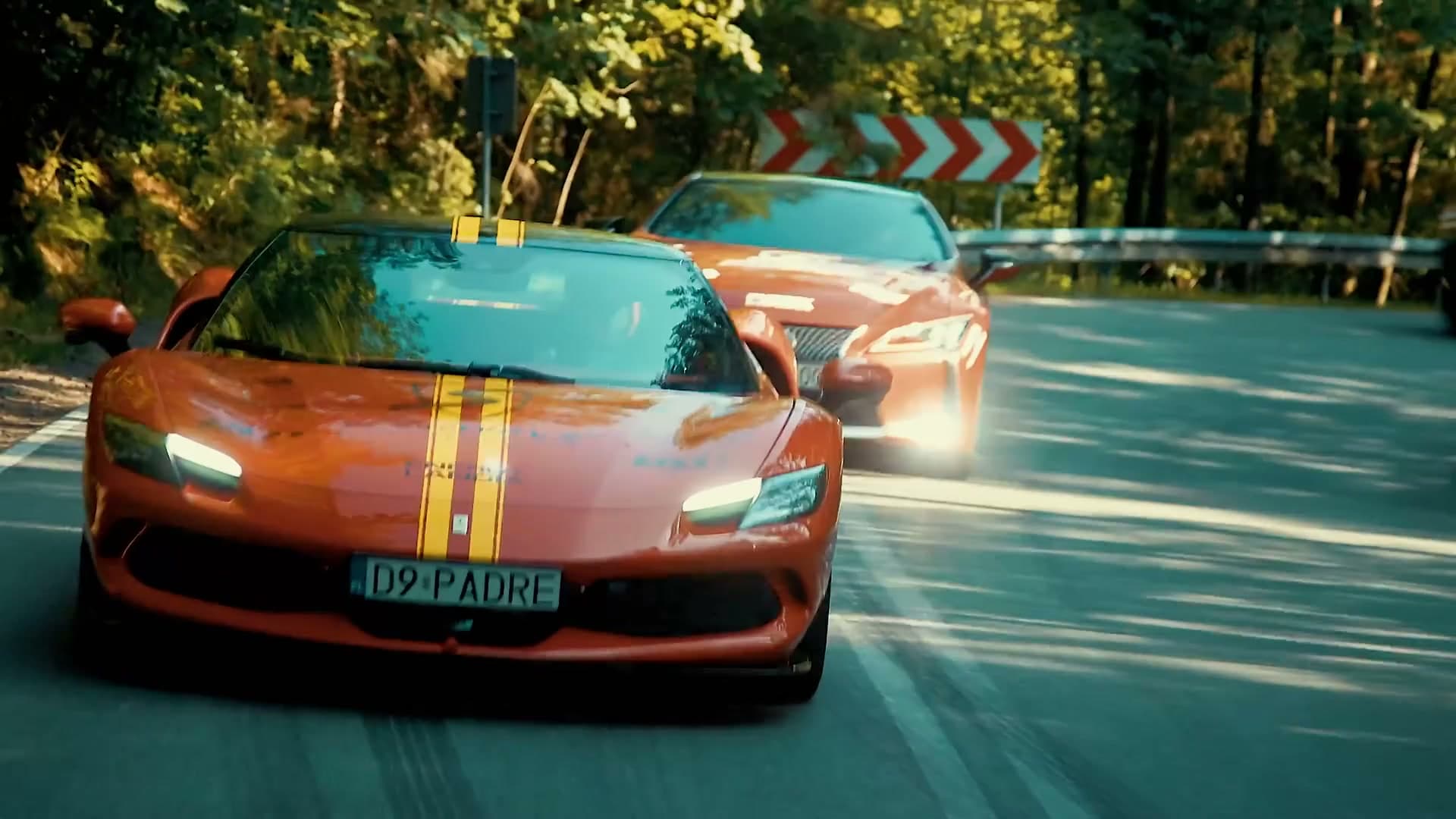 Kolumna Ferrari Positive Ways na leśnej drodze, pasażer macha z kabrioletu